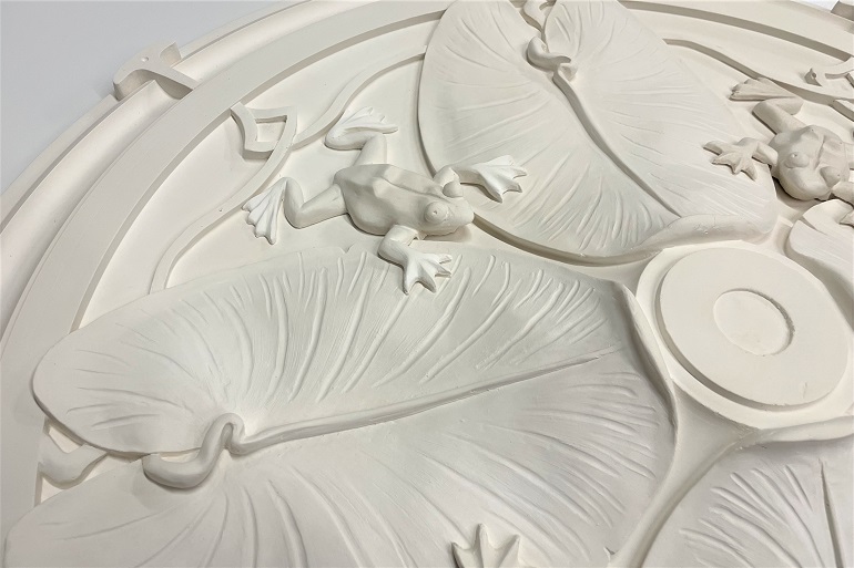 Detail van gemodelleerde kikker en waterlelieblad in Art Nouveau rozet